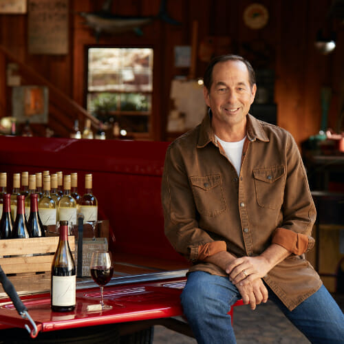 Joseph Carr sitting next to crate of wine