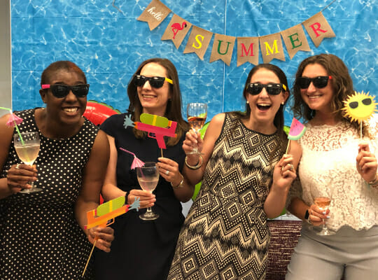 Employees smiling and enjoying a summer event