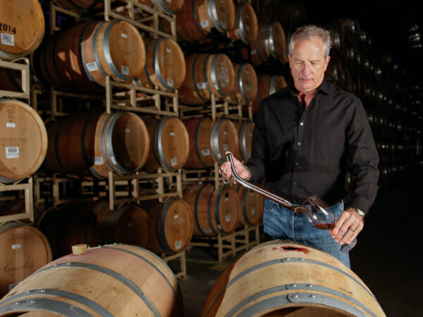 Winemaker pouring sample from barrel