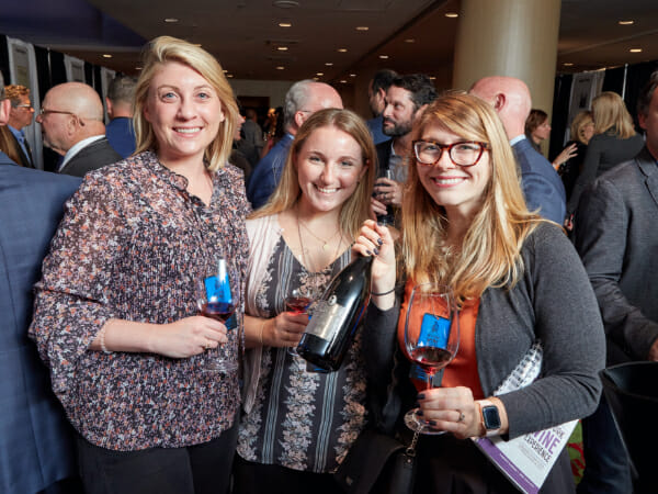 Three women smiling with wine glasses