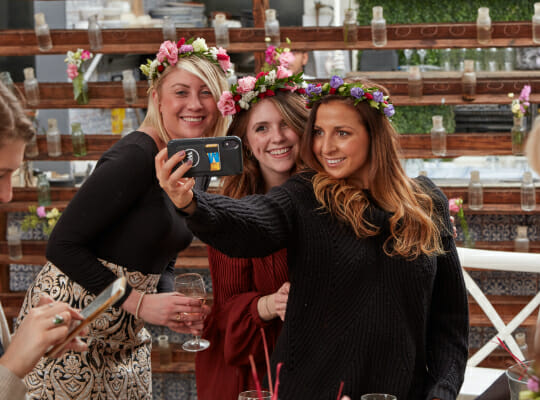 Employees taking selfie with flowers in hair